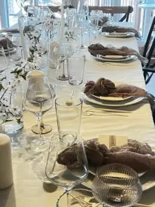 Elegant dining table set for a dinner party in Atlanta, featuring glassware, decorative napkins, and floral accents, highlighting the private chef experience offered by Culinary Collective ATL.